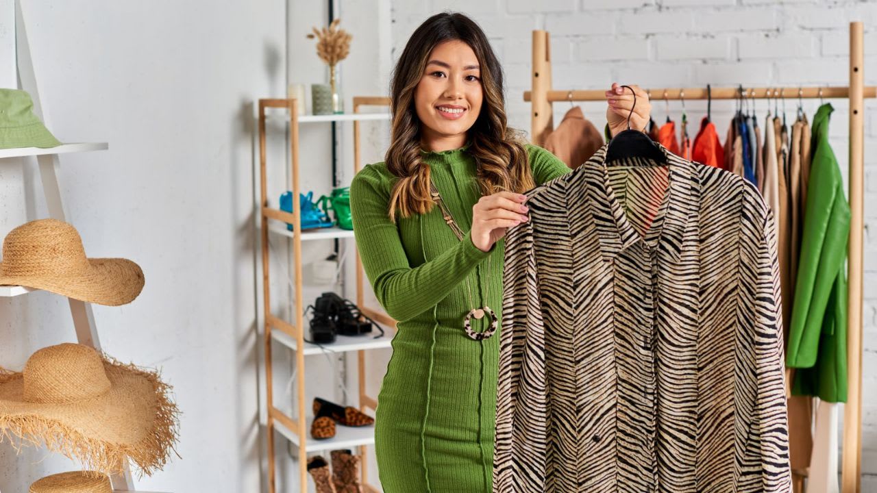 Asian fashion stylist happy with a custom design